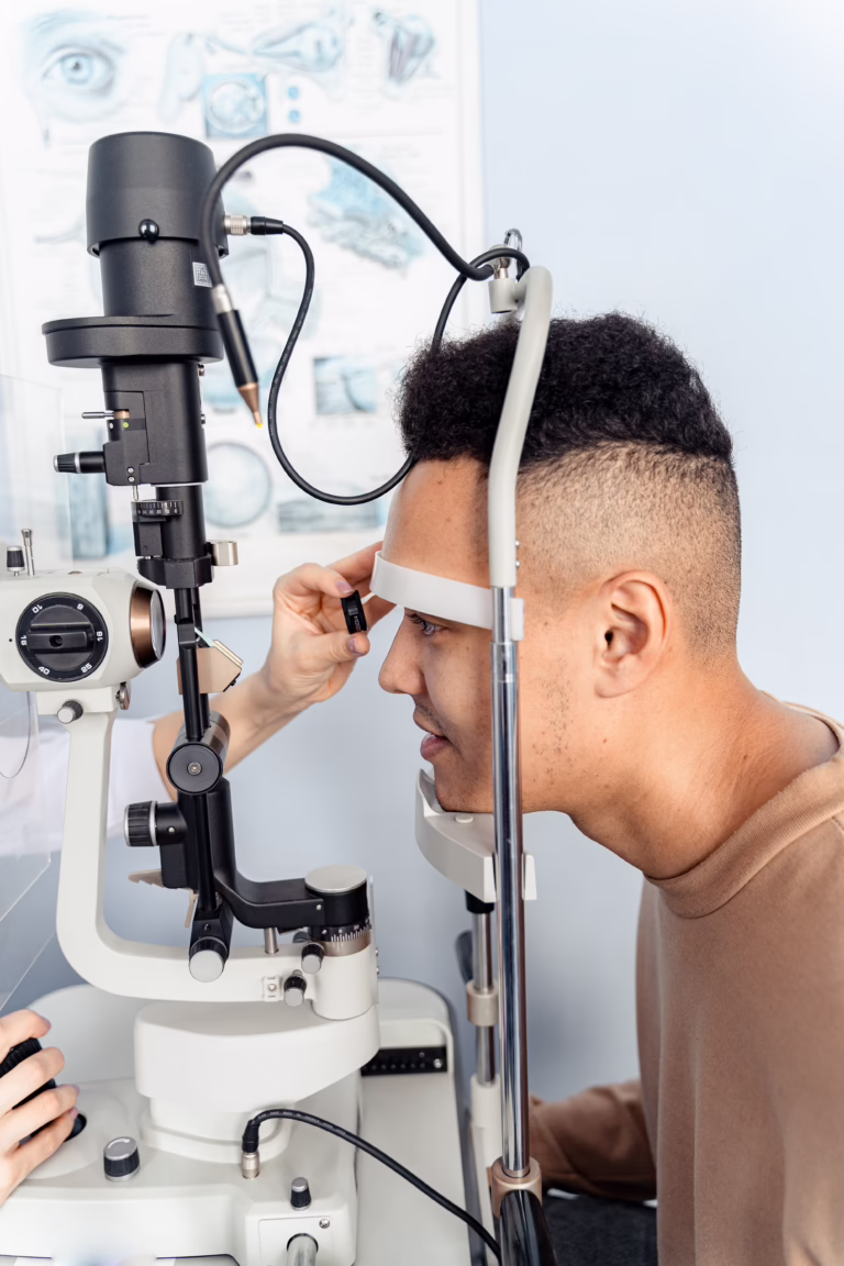 An ophthalmologist examines a patient's eye using a slit lamp microscope during an eye exam.